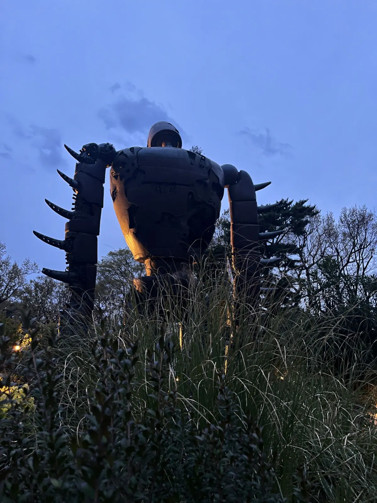 The robot soldier from Castle in the Sky on the Ghibli Museum rooftop at dusk